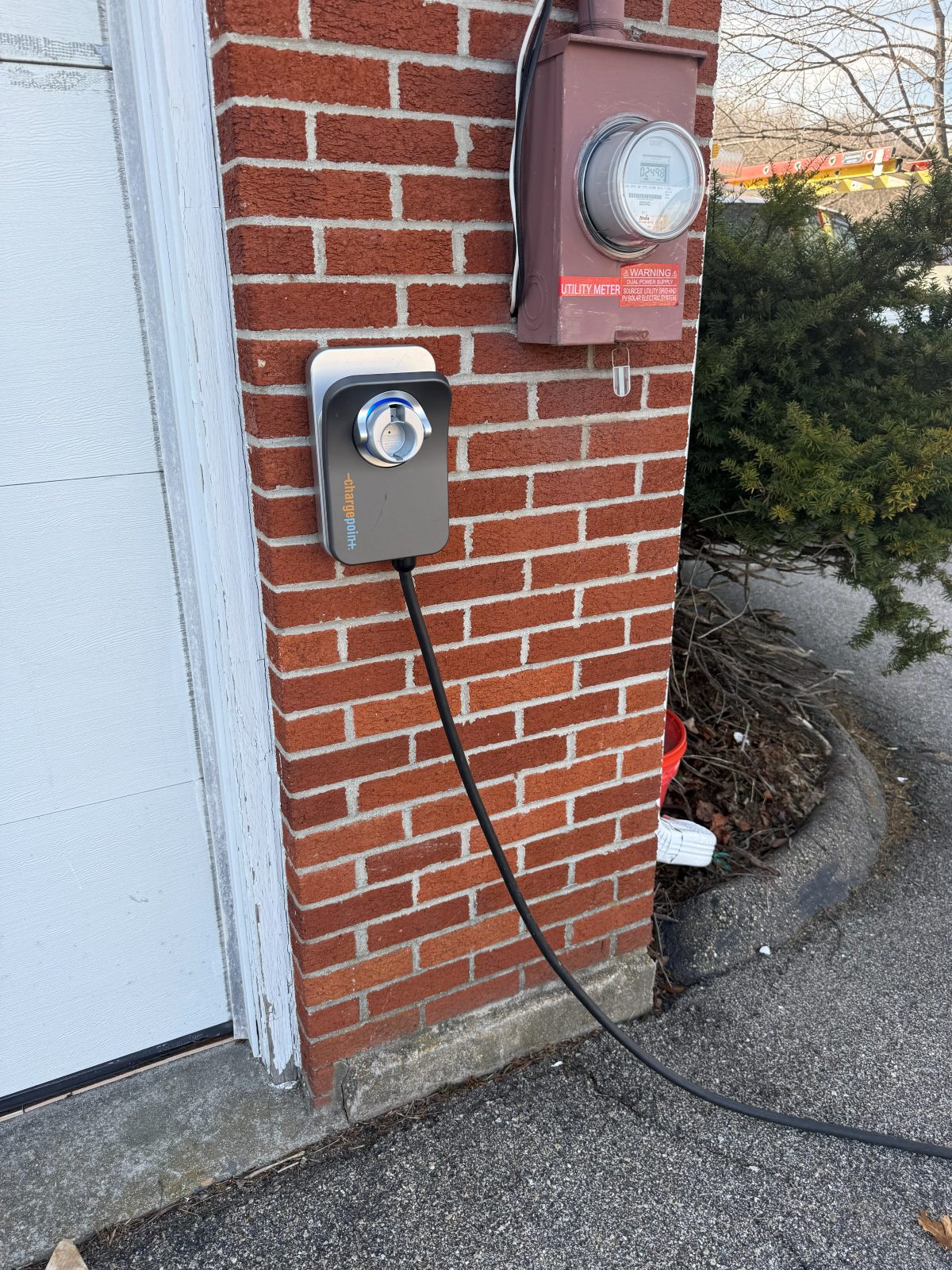 EV charger on a brick wall next to the meter